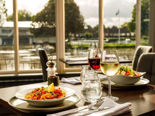 a table with two plates of food and glasses of wine at Sunday London Staines-upon-Thames Heathrow T5 in Staines