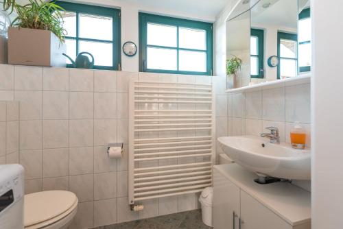 une salle de bain blanche avec un lavabo et des toilettes dans l'établissement Ferienwohnungen "Zur Linde am Achterwasser", à Zempin