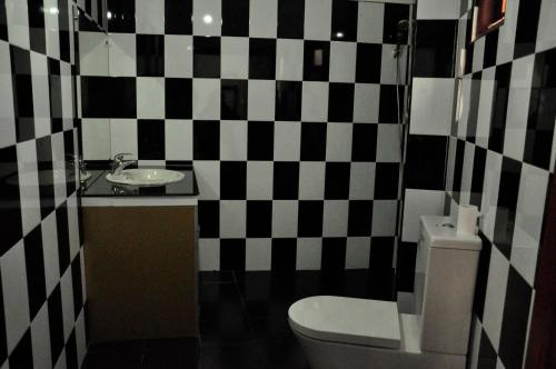 a bathroom with a black and white checkered wall at Cool Beach Hotel in Hikkaduwa
