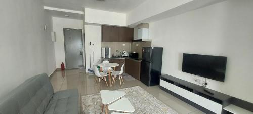 un salon avec un canapé et une table avec des chaises dans l'établissement Shahdila Alinea parking level 2, à Shah Alam