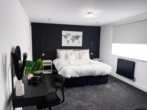a black and white bedroom with a bed and a desk at Weekly Offer 2Bed 2Bath Self CheckIn Wifi Car Park in Peterborough