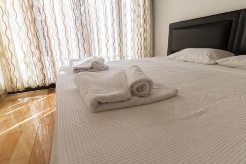a bed with two towels sitting on top of it at Peanut House by HolidayKeys in Kérynia