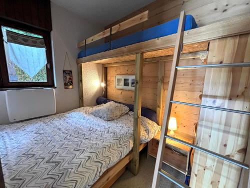 une chambre avec un lit superposé et une échelle dans l'établissement CYBELE C1 appartement proche village et pistes, à La Clusaz