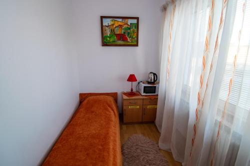 a room with a bed and a microwave and a window at Centrum One in Suwałki