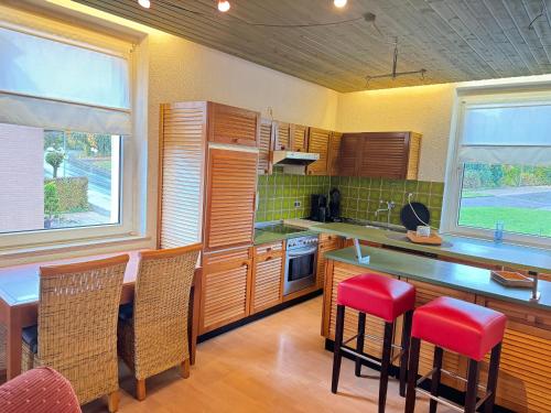 a kitchen with wooden cabinets and red bar stools at Hotel Rio in Horn