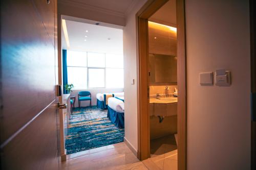 a room with a bathroom with a sink and a mirror at Taj Park Hotel in Makkah
