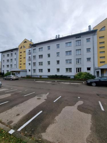 an empty parking lot next to a large white building at Exclusive Golden Sands apartment in Rīga