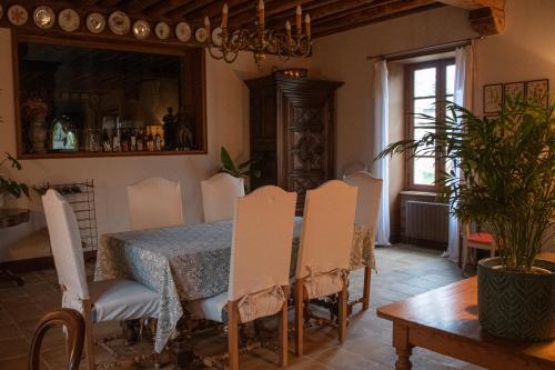 a dining room with a table and chairs at Les Jardins de la Beylie - Chambre d'hôtes in Preyssac-dʼAgonac