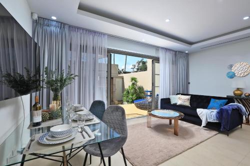 a living room with a couch and a table at Villa 242 - private pool, fast internet in Ban Thalat Choeng Thale