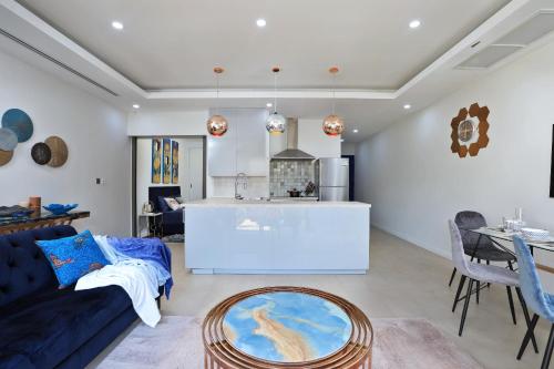 a living room with a blue couch and a kitchen at Villa 242 - private pool, fast internet in Ban Thalat Choeng Thale