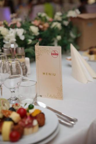a plate of food on a table with a menu at Nicolas in Cîmpia Turzii