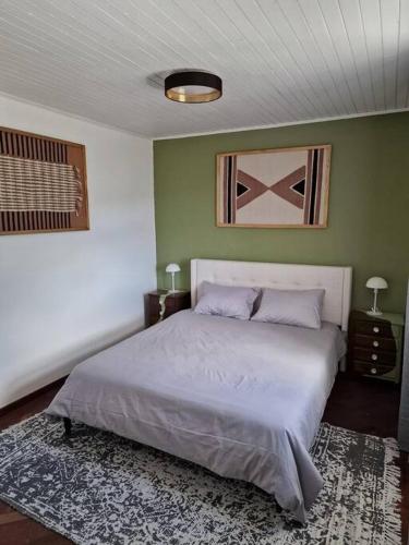 a bedroom with a large bed and green walls at Casa Vieira in Fajã da Ovelha