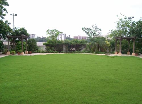 a large field of green grass with a fence at Sarovar Portico Rivera Ahmedabad in Ahmedabad