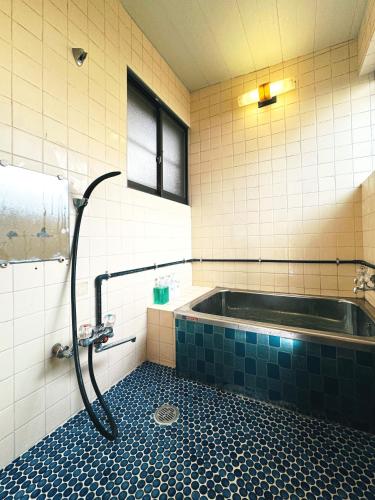 a bathroom with a bath tub with a shower at #12 -関ヶ原 蛍- 古民家の宿 in Sekigahara