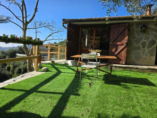 a table and chair on a lawn with a house at La sosta al bagolaro in Rapallo
