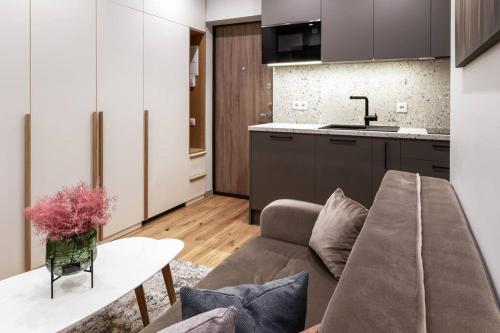 a living room with a couch and a kitchen at Cozy Quiet City Center Apartment in Klaipėda