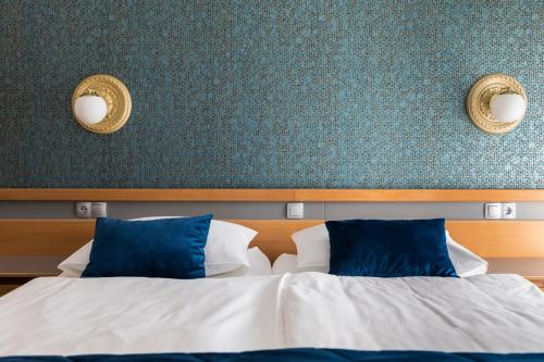 a bedroom with a bed with blue and white pillows at Hotel Alp in Bovec
