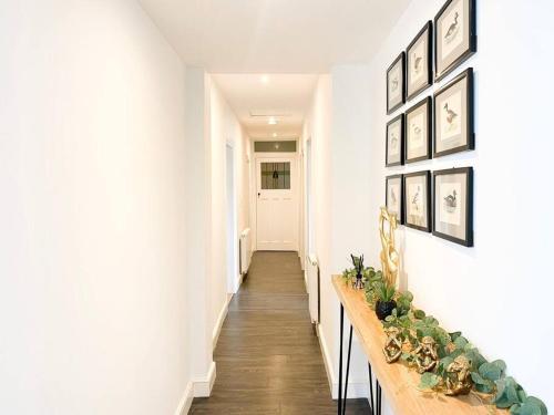 a hallway with a long table with plants on it at Lakeway in Penrith