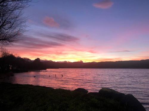 a sunset over a body of water with ducks in it at Lakeway in Penrith