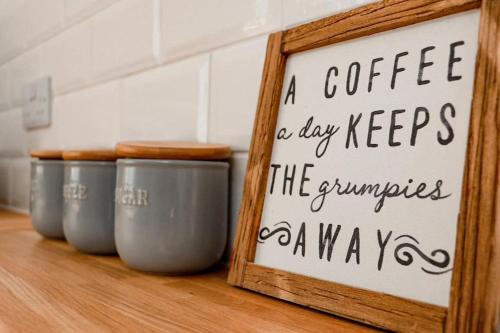 a sign in a wooden frame next to four cups at Lakeway in Penrith