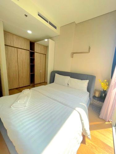 a large white bed in a room with at Stylish 1BR Condo by BTS Ekkamai - Infinity Pool & Gym in Khlong Toei