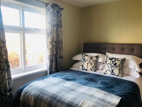 a bedroom with a bed with pillows and a window at Lakeway in Penrith