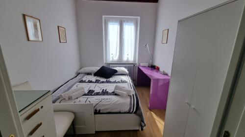a small bedroom with a bed and a window at Evergreen House - Japartments in Genova
