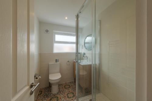 a bathroom with a toilet and a glass shower at Florence Gardens Boutique Hotel and Restaurant in Portsmouth