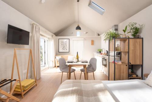 a room with a bed and a table and chairs at The Rest House in Porthcurno