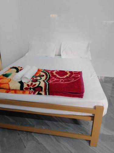 a bed with a wooden frame with a blanket on it at Eha Mundro Island Homestay in Munroe Island