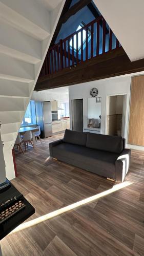 un salon avec un canapé et un escalier dans l'établissement Famille SABLJAK, à Marles-en-Brie