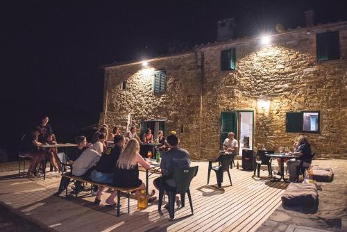 a group of people sitting at tables in front of a building at Agriturismo I Poggilunghi in Civitella in Val di Chiana