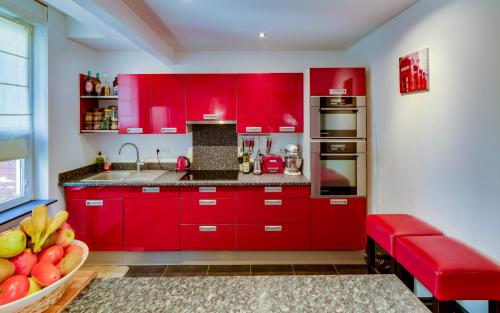 - une cuisine avec des placards rouges et un bol de fruits dans l'établissement CHAMBRE EN VILLE TRèS COSY !, à Nancy