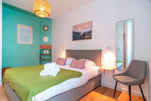 une chambre avec un grand lit et une chaise dans l'établissement Escale jardin - Joli apt proche gare avec jardin, à Vannes