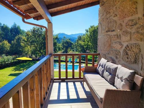 a porch with a couch and a view of a pool at Casa doNegrinho com Piscina in Monção
