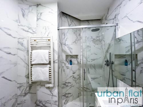 La salle de bains est pourvue d'une douche en marbre blanc. dans l'établissement Urban Flat 61 - Pretty 3 Bedrooms in Center of Paris, à Paris