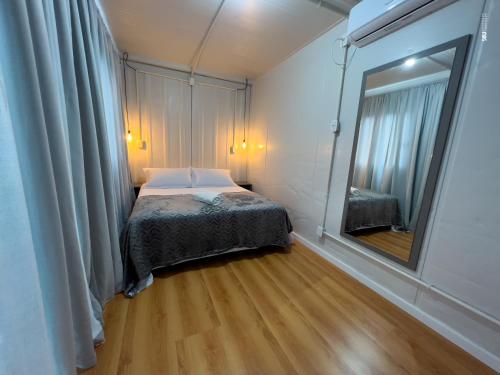 Ametista do SulPousada Container e Spa Mina Beer的一间带床和镜子的小卧室