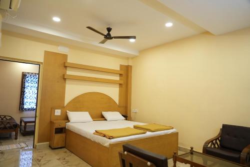 a bedroom with a bed and a ceiling fan at Sri Krishnan Residency in Pollāchi