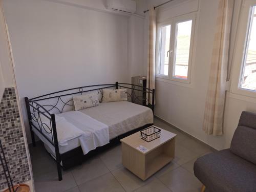 a small bedroom with a bed and a couch at Αργέντη in Chios