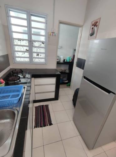 a kitchen with a sink and a refrigerator at Mateen Cottage II in Tanah Rata