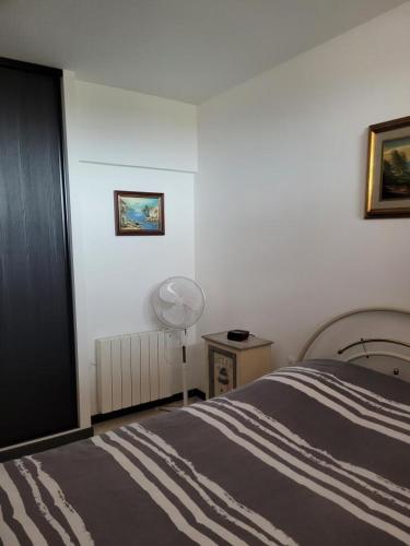 - une chambre avec un lit, une lampe et un ventilateur dans l'établissement Direct sur plage pour ce charmant T2 avec parking privatif - 4OND28, à Saint Cyprien Plage