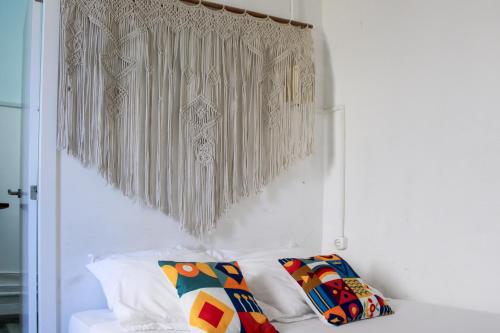 a room with a bed with pillows and a curtain at Urban Suites in Aveiro