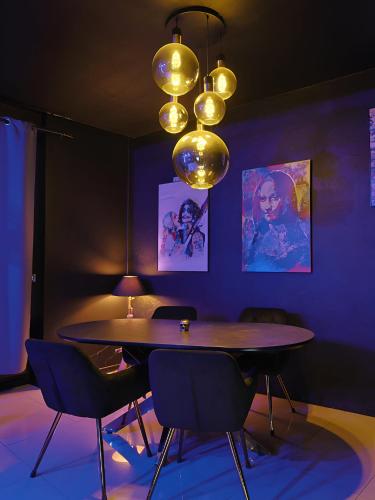 une salle à manger avec une table, des chaises et un lustre dans l'établissement Appartement POP ART - Asterix,CDG,Chantilly,Disney, à La Chapelle-en-Serval
