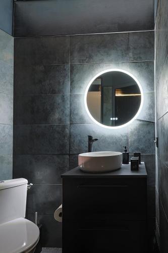 une salle de bain avec un lavabo et un miroir dans l'établissement Appartement POP ART - Asterix,CDG,Chantilly,Disney, à La Chapelle-en-Serval