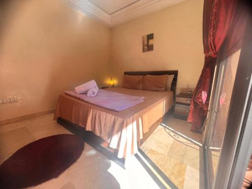 a small bedroom with a bed with purple sheets at Hivernage prestige in Marrakech
