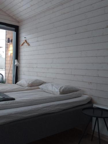 two beds in a room with a brick wall at Willa Rauha G, minikoti rauhallisella sijainnilla, ei saunaa in Lumijoki