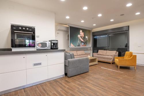 a living room with a couch and chairs and a tv at אחוזת כנען - וילה מדהימה עם בריכה פרטית מחוממת וג'קוזי in Yarka