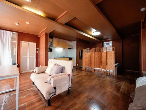 a living room with a couch and a kitchen at #15 -青葉 葵- 古民家の宿 自然が癒すひと夜を過ごす宿 in Shiomidai