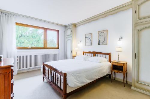 une chambre avec un grand lit et une fenêtre dans l'établissement Mélodie Mosellane - Charmant appt avec jardin, à Metz