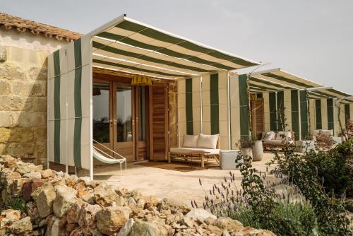 a house with a green and white striped canopy at Amagatay Luxury Boutique Hotel - Adults Only in Alaior